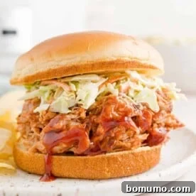 Slow cooker pulled pork on a bun with coleslaw.