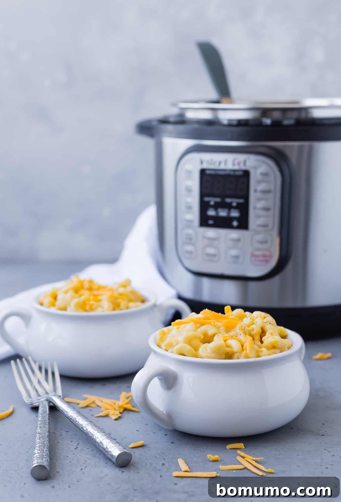 Macaroni and cheese in bowls, with an Instant Pot in the background.