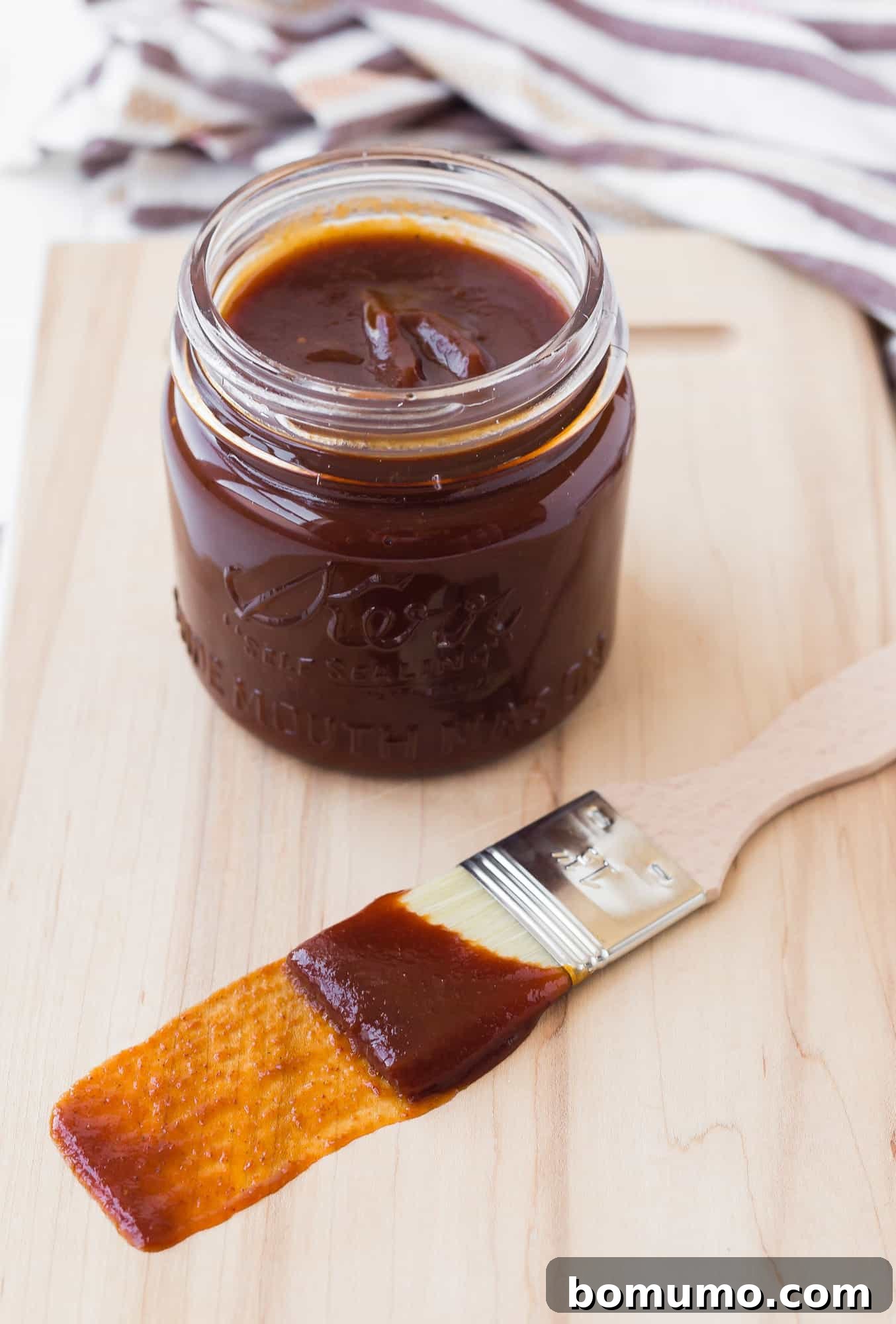 BBQ sauce in a jar and on a brush, ready to be used.