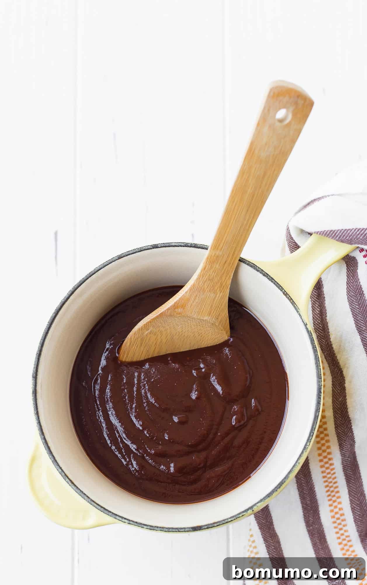 Homemade BBQ sauce simmering in a small saucepan.