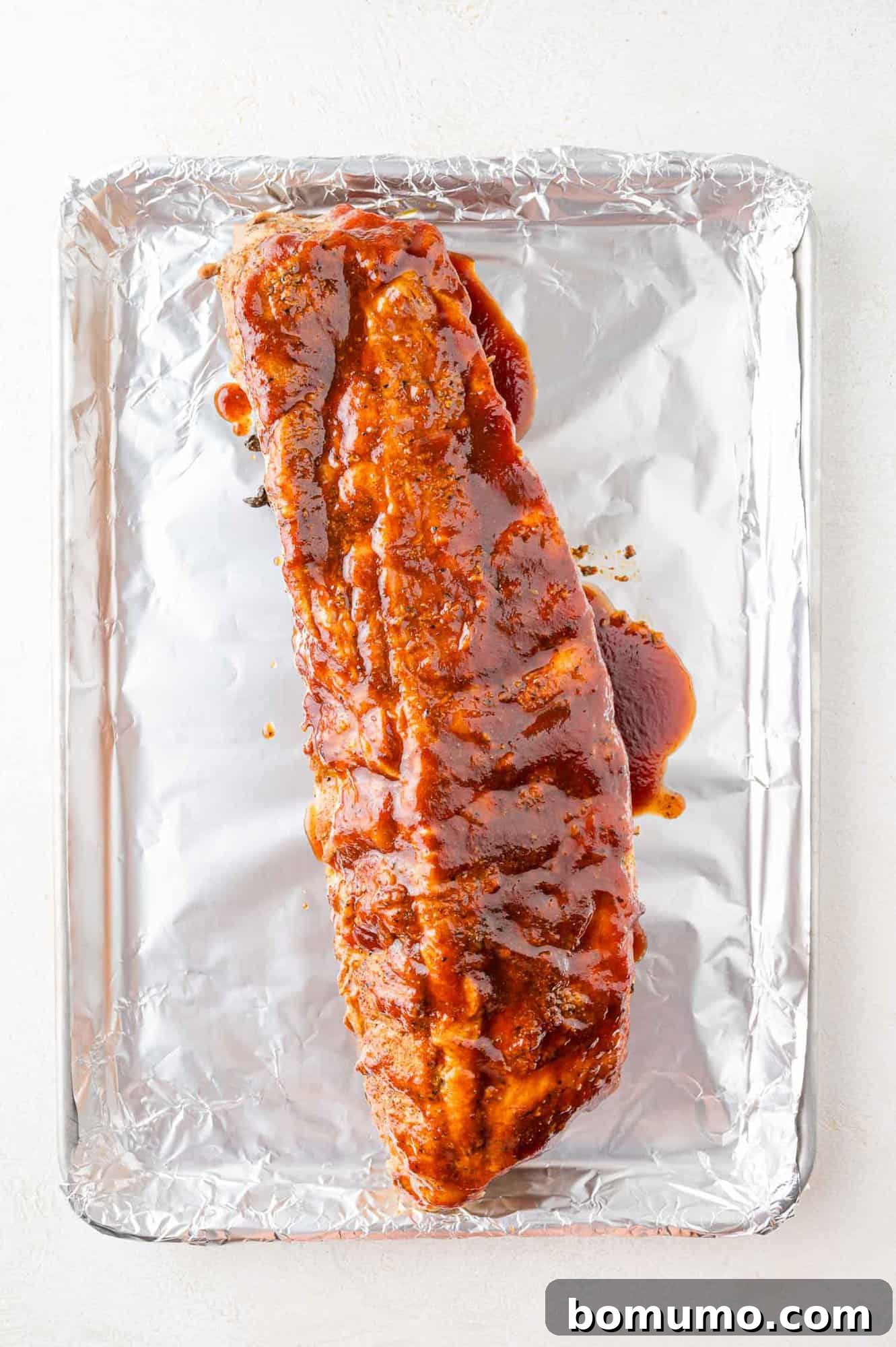 Instant Pot Ribs: Quick & Delicious 11 Ribs on a foil-lined baking sheet, ready to be broiled.