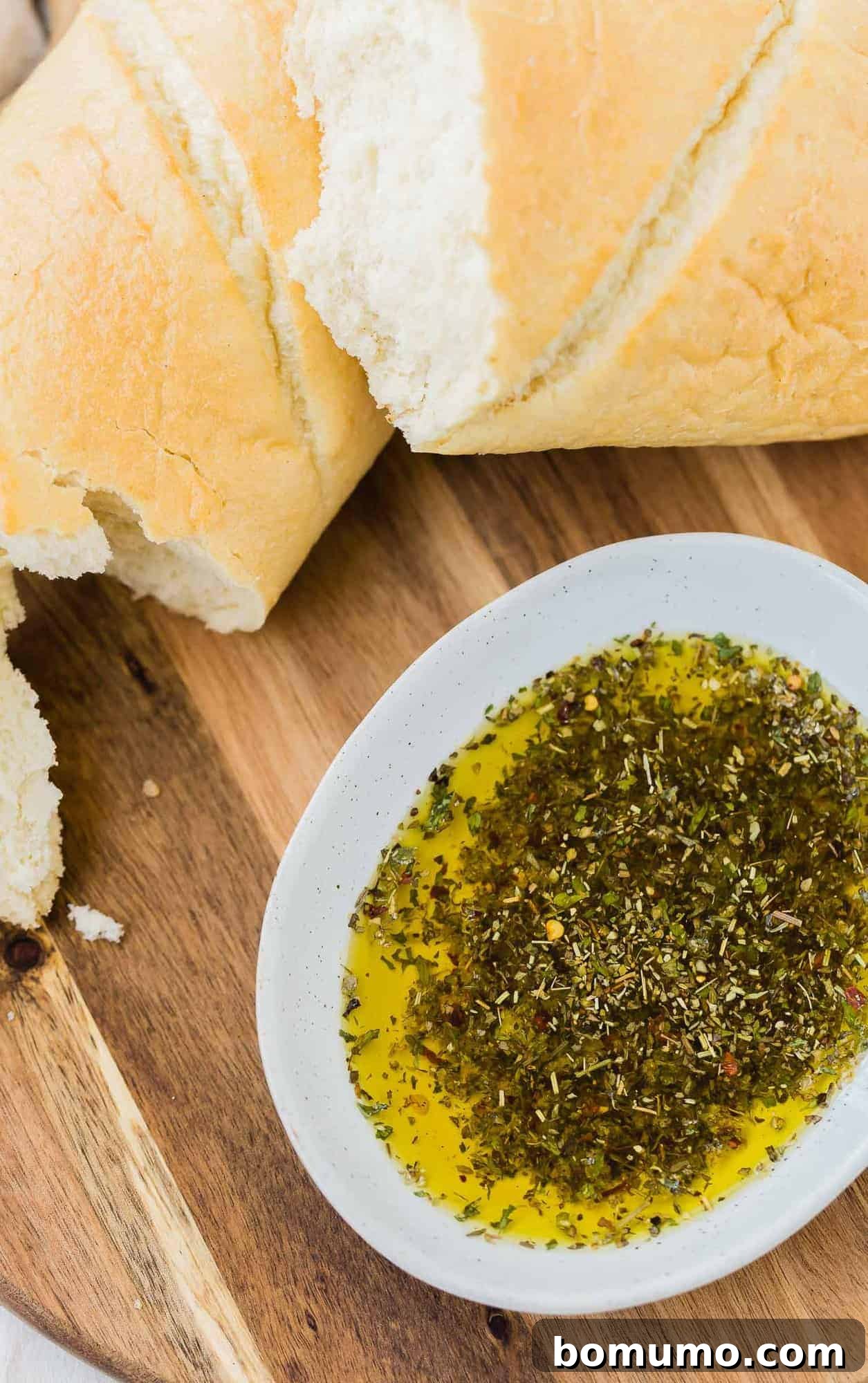 Bread dipping oil with bread on a wooden surface