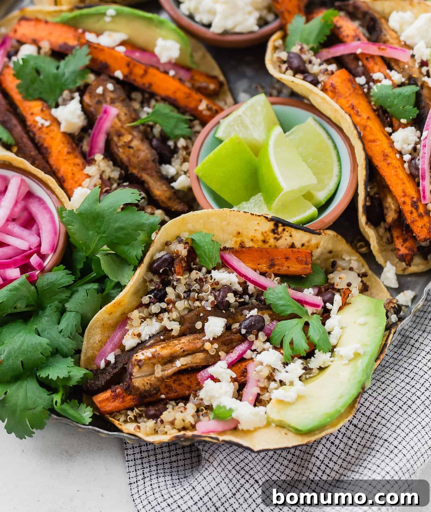 Plant Powered Roasted Tacos 3 A close-up shot of a single roasted carrot, mushroom, quinoa, and black bean taco, showcasing its rich fillings and vibrant ingredients.