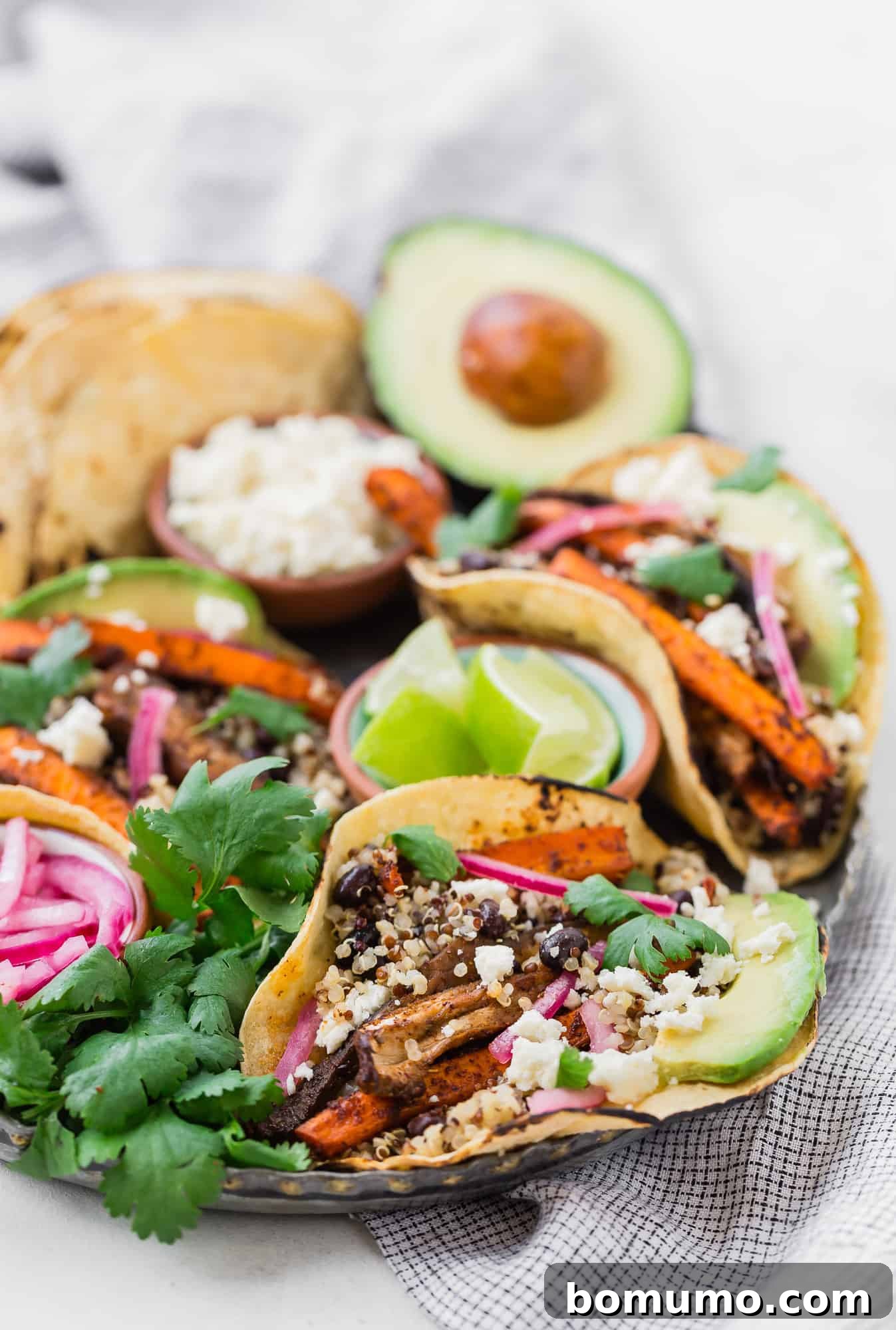 Plant Powered Roasted Tacos 5 A beautifully arranged platter of finished tacos, garnished with an array of fresh and vibrant toppings, ready to be enjoyed.