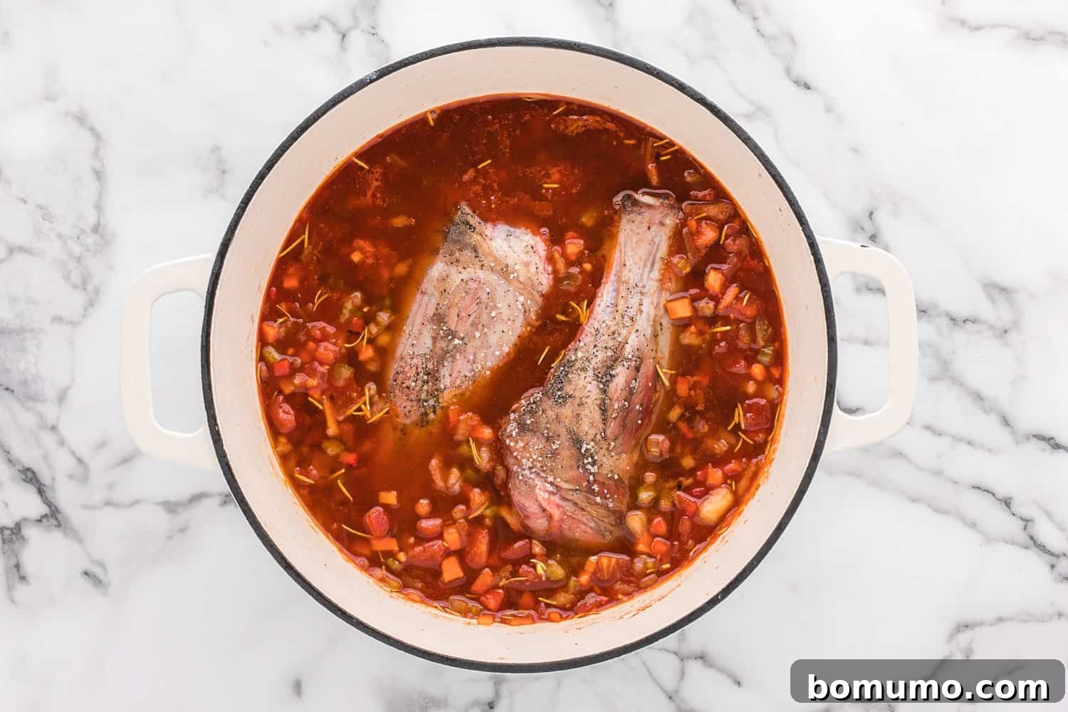Uncooked lamb shanks carefully placed back into a Dutch oven, surrounded by a rich braising liquid, ready for slow cooking.