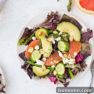 Overhead of salad on small white plate with forks, showcasing the vibrant ingredients.