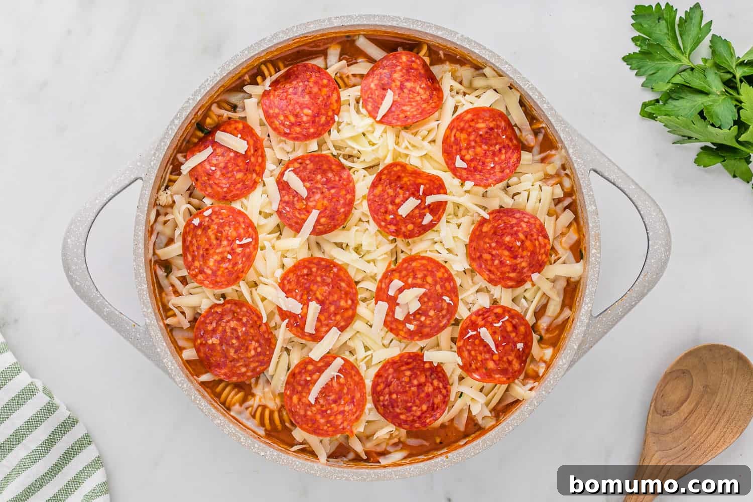 One-Pan Pizza Pasta with additional pepperoni and unmelted shredded cheese on top, ready for broiling.