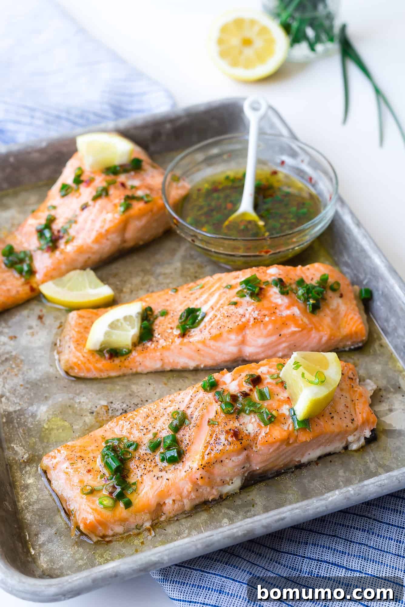 This flavorful baked salmon with lemon and chives is a taste of summer! It's the ultimate healthy, easy dinner idea, ready in 30 minutes. Perfectly baked salmon fillets on a sheet pan, garnished with fresh lemon slices and vibrant chives, ready to be served.