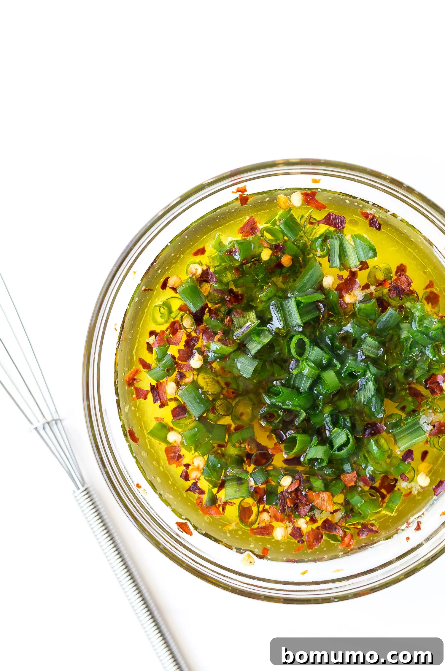 This flavorful baked salmon with lemon and chives is a taste of summer! It's the ultimate healthy, easy dinner idea, ready in 30 minutes. A small, elegant bowl filled with a vibrant lemon chive sauce, showcasing its fresh green and yellow hues.
