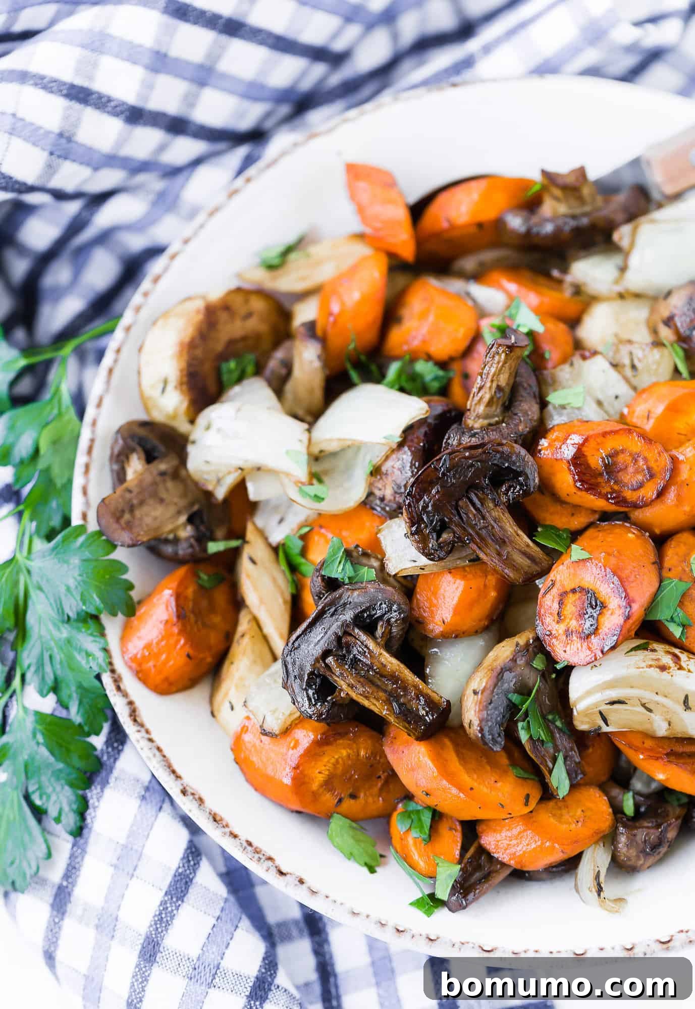 Golden Balsamic Roasts 4 Cooked vegetables in a bowl with parsley.