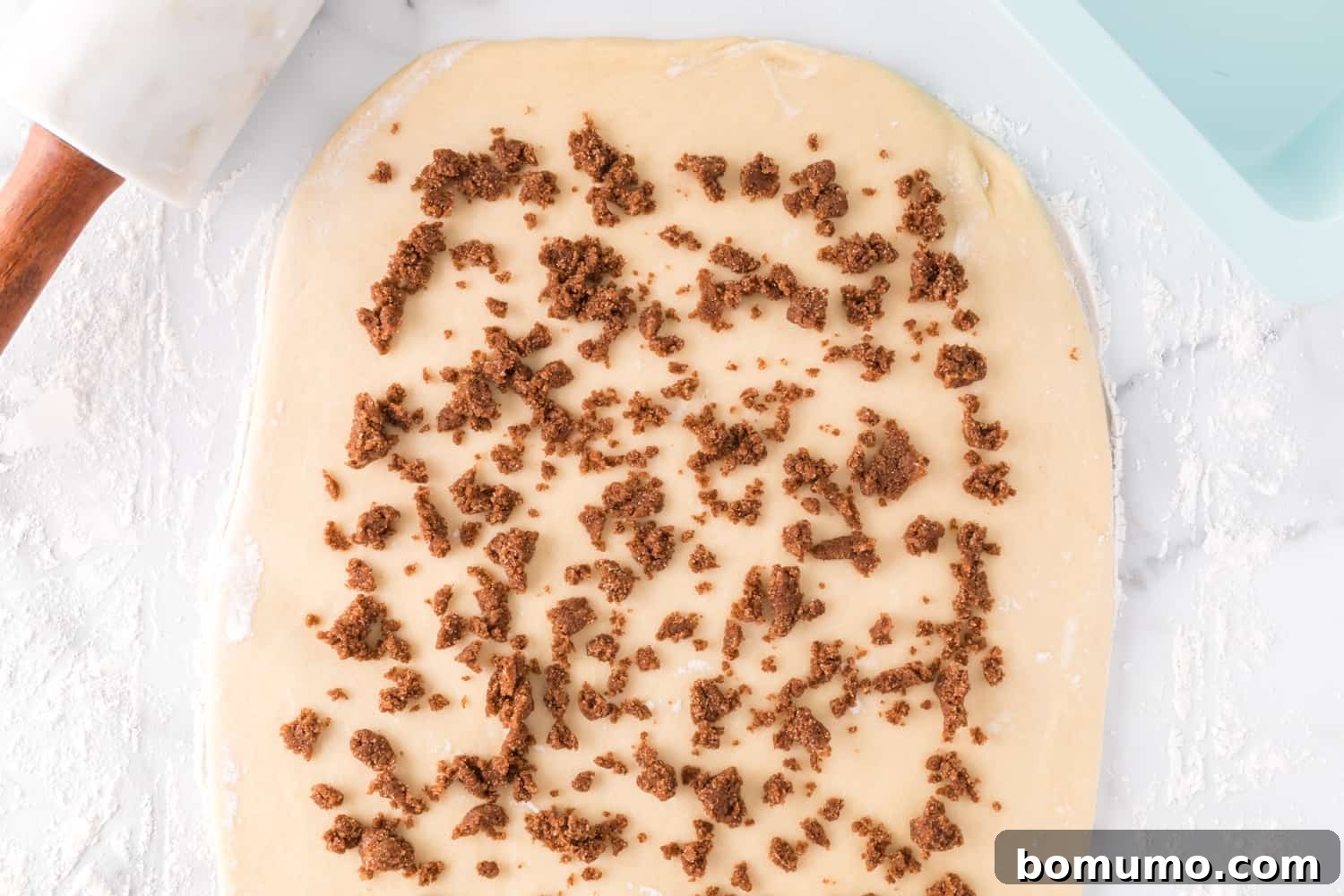 Rolled out dough evenly sprinkled with the cinnamon swirl mixture.
