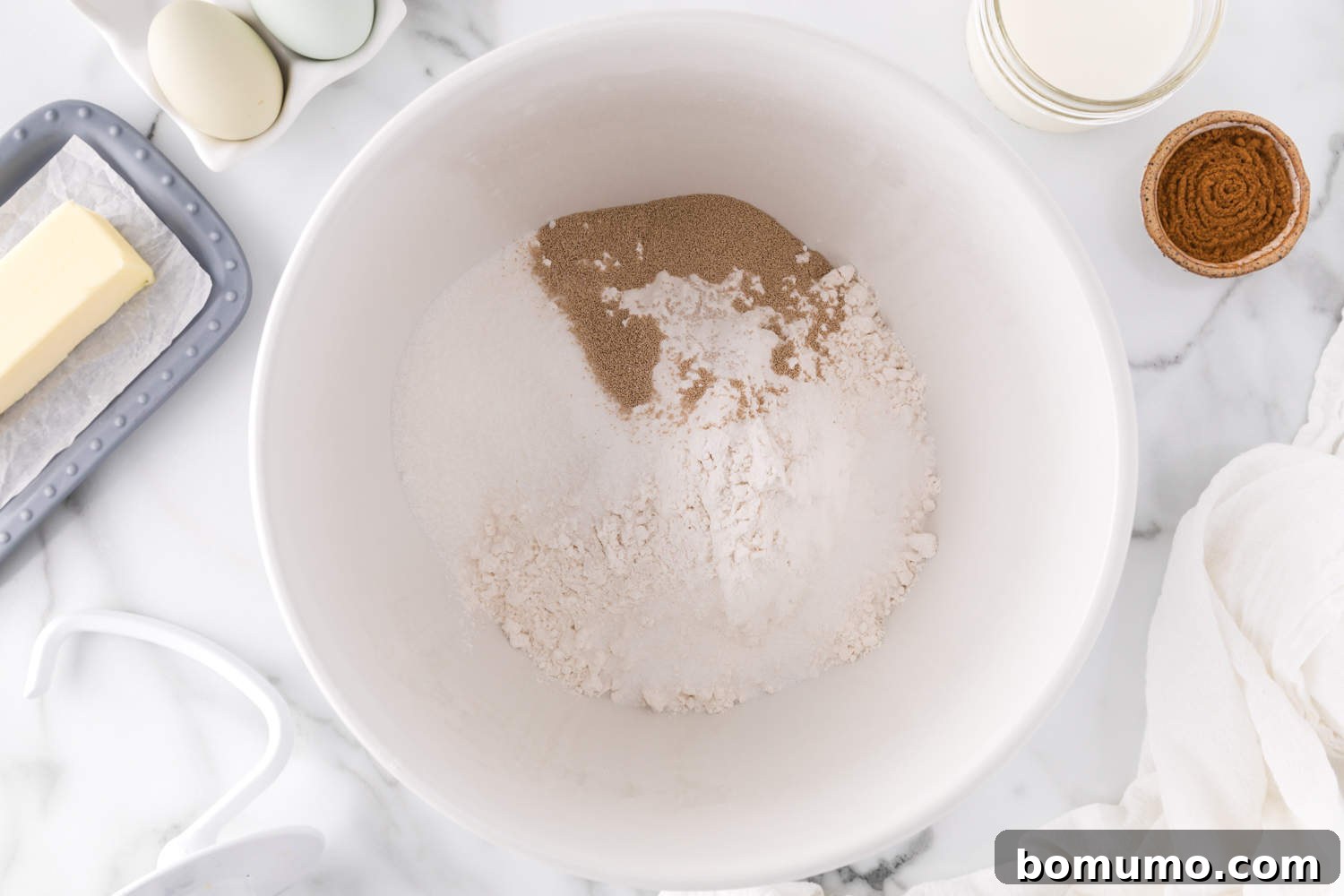 Dry ingredients for cinnamon swirl bread in a stand mixer bowl before mixing.