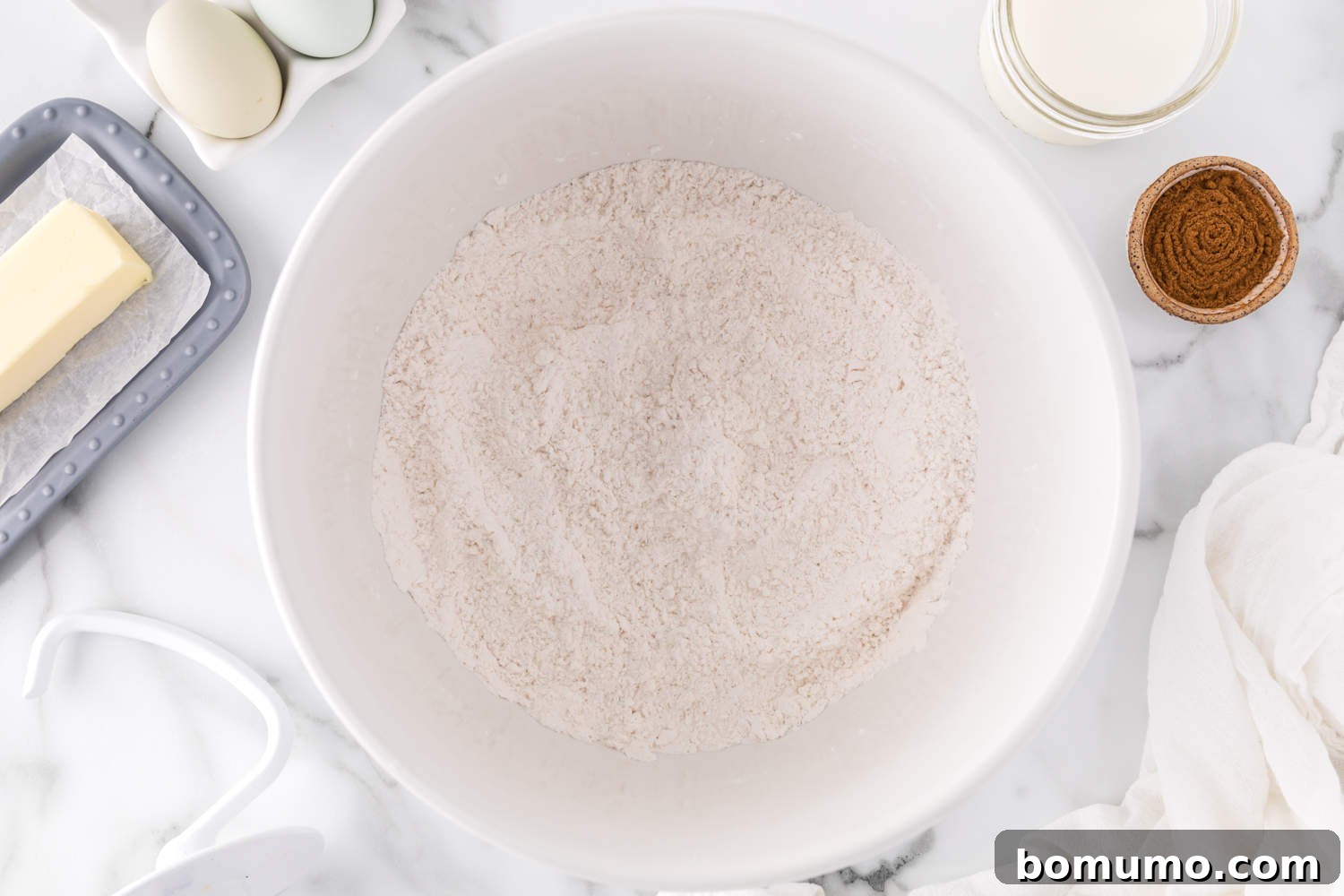 Dry ingredients for cinnamon swirl bread thoroughly mixed together in a stand mixer bowl.