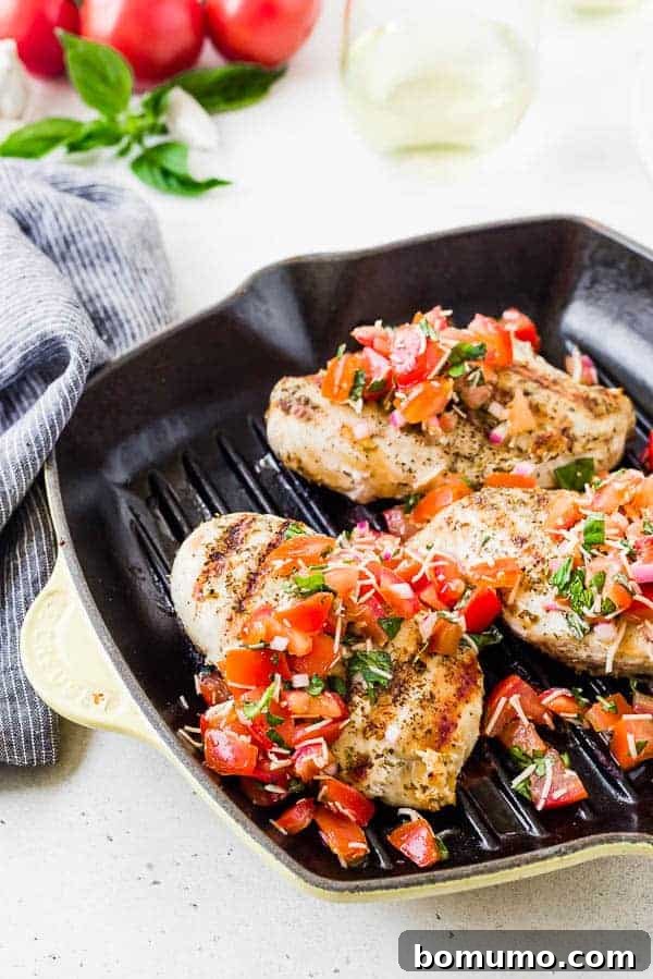 image of chicken in a grill pan topped with tomato and basil