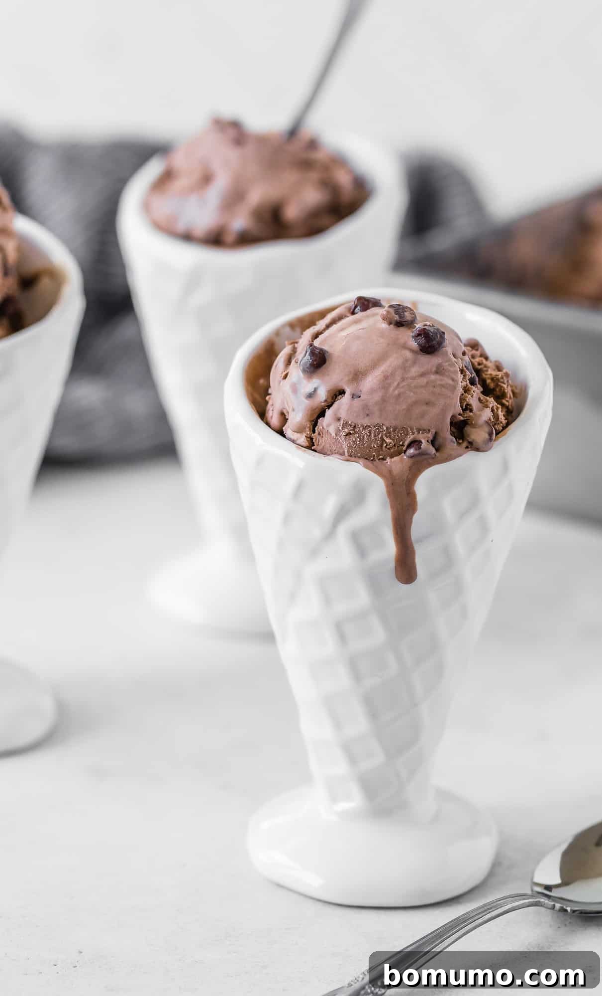 Decadent no-churn double chocolate ice cream presented in a white ceramic cone, showcasing its rich texture and delicious chocolate chips.