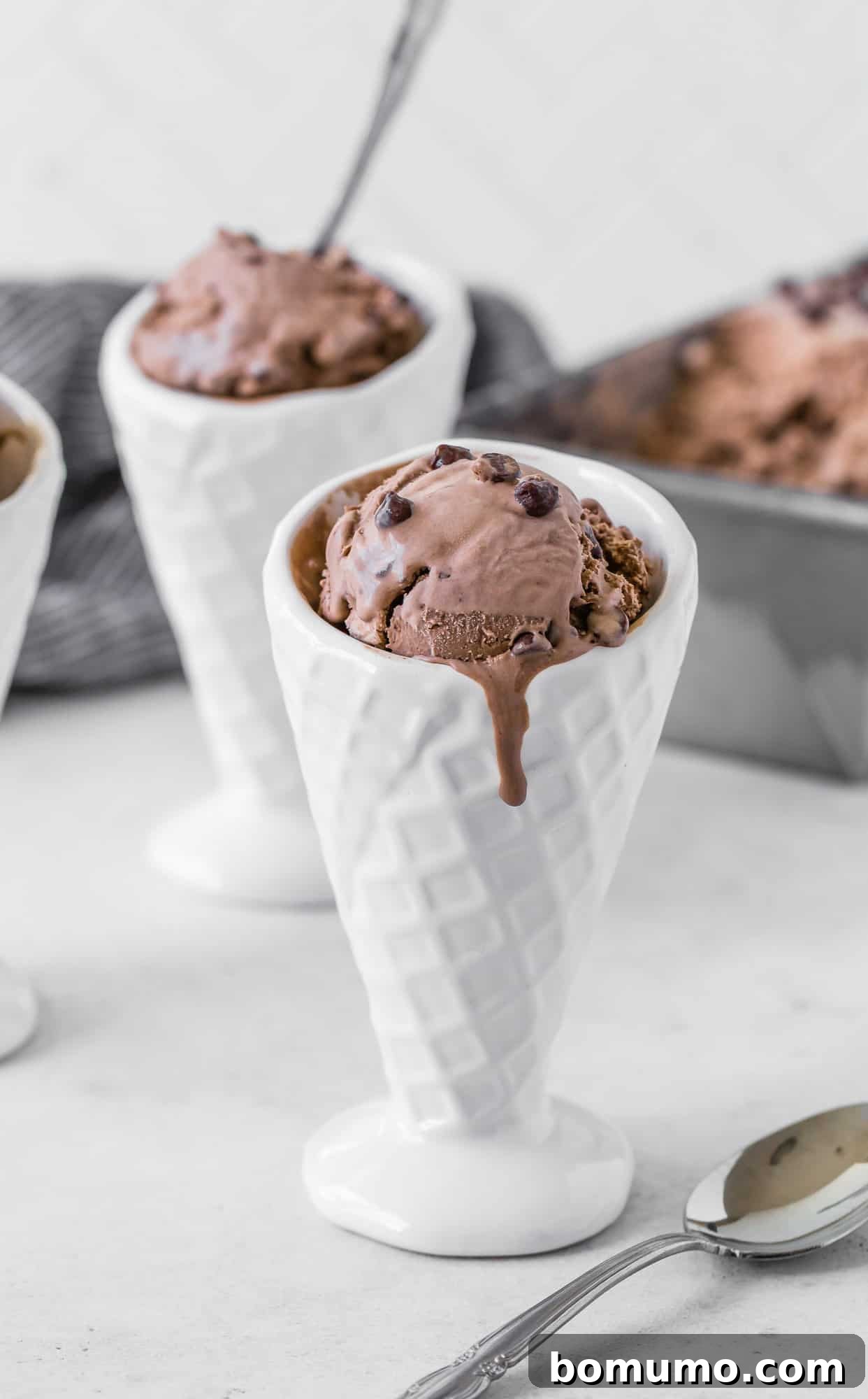 Rich chocolate ice cream melting beautifully down a crisp white ceramic cone, tempting and delicious.