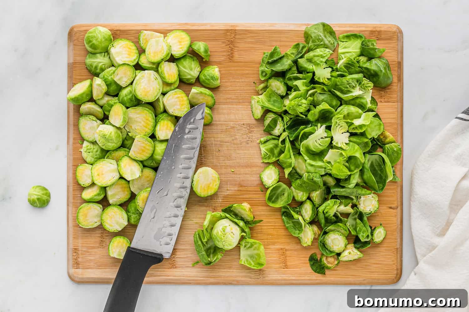 Brussel sprouts, trimmed, knife on cutting board.