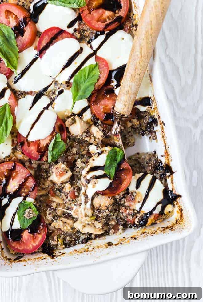 Partial overhead view of quinoa bake with a wooden handle spoon scooping a portion out.
