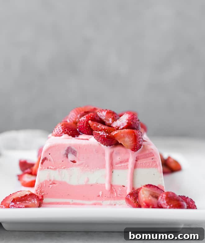 Image of ice cream terrine with layers of strawberry and vanilla ice cream. Topped with roasted strawberries that are still slightly warm, causing the ice cream to start to melt just slightly. A perfect blend of elegance and simplicity.