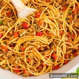One pot Mexican spaghetti in a pan with a serving spoon.