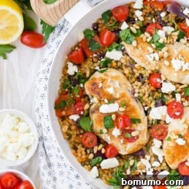 One pan chicken and couscous in a white skillet.