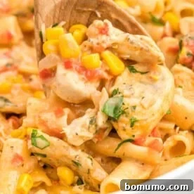 Cajun chicken pasta with a wooden spoon.