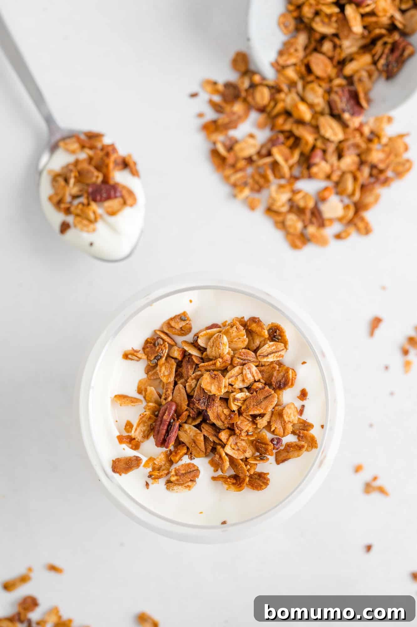 Homemade granola sprinkled generously over creamy yogurt, creating an inviting and wholesome breakfast or snack option.