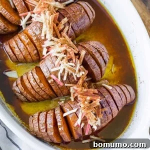 Hasselback sweet potatoes in a white baking dish.