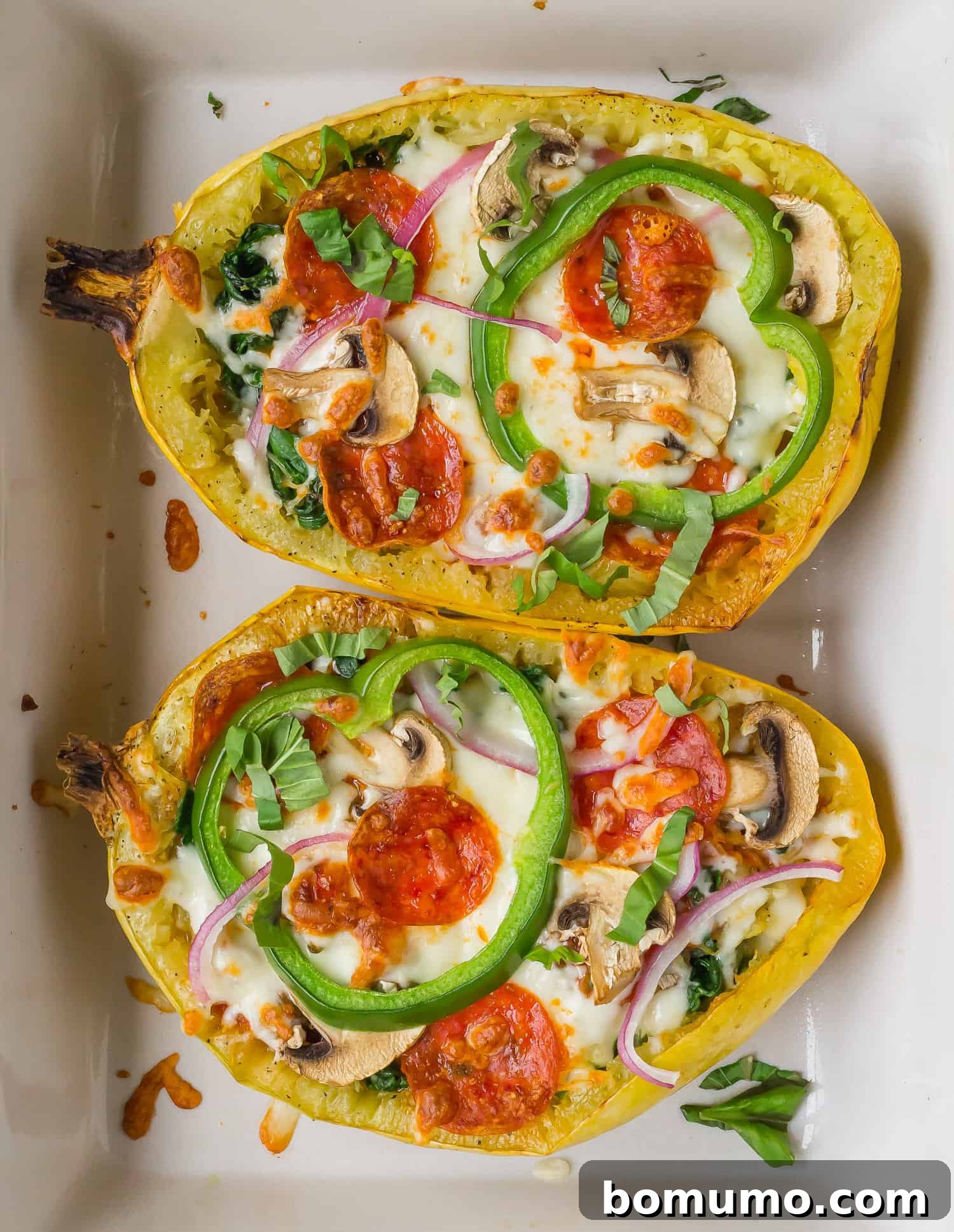 Delicious pizza stuffed spaghetti squash featuring melted cheese, savory pepperoni, and vibrant vegetables, served directly in its natural squash bowl.