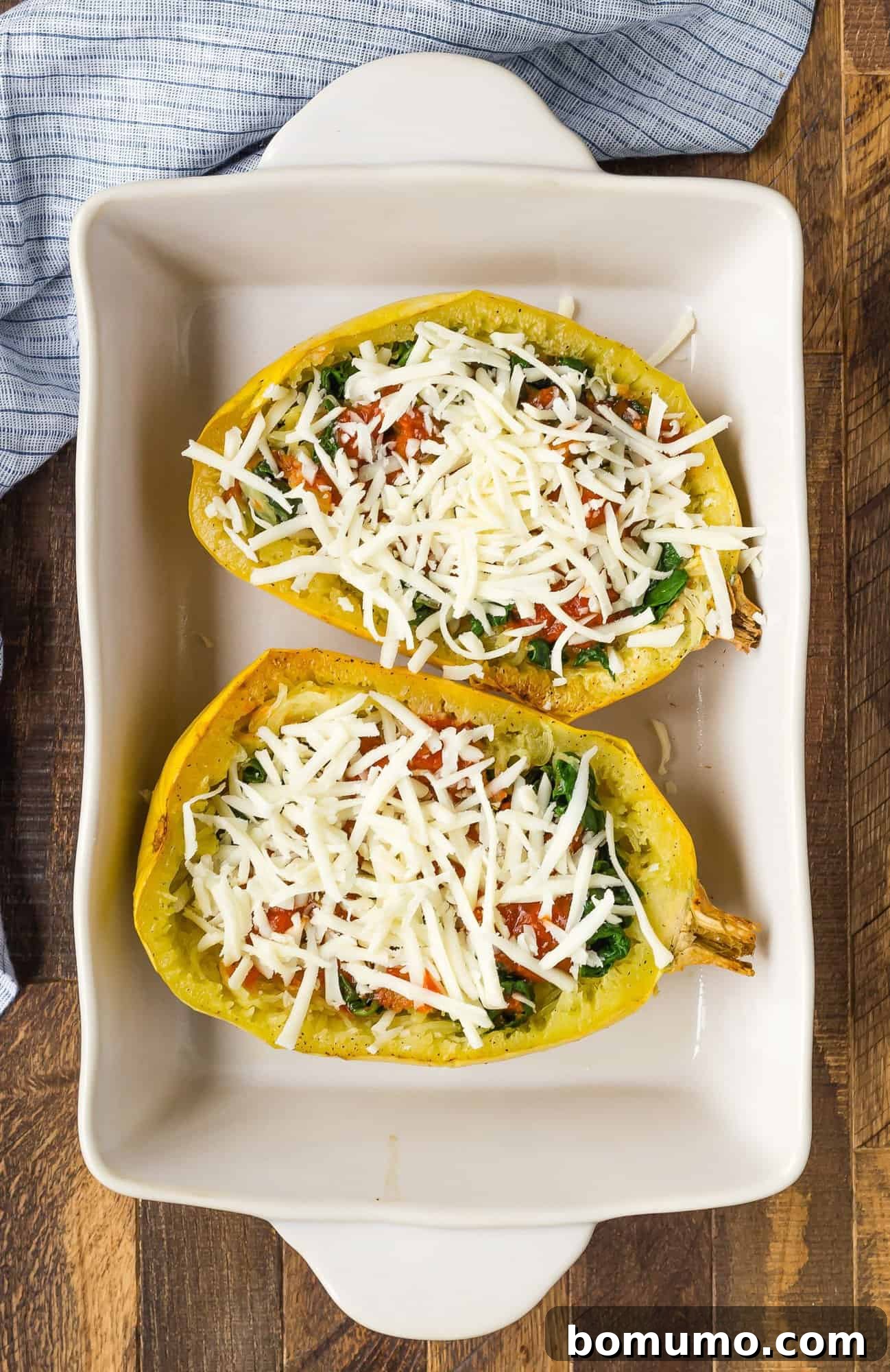 Abundant shredded mozzarella cheese evenly distributed over the pizza sauce and squash strands, ready to be adorned with additional pizza toppings.