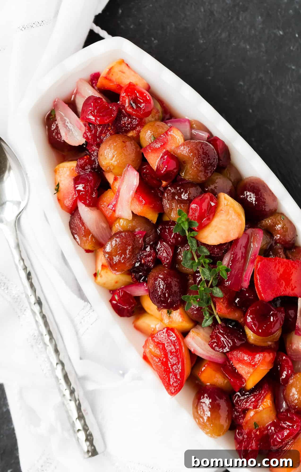 Vibrant cranberry sauce with roasted grapes, apples, and shallots, perfect for a holiday spread.