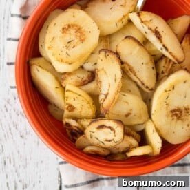 Perfectly sautéed parsnips in an elegant orange serving bowl.