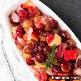Cranberry sauce with roasted grapes and shallots in a decorative bowl.