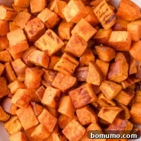Close-up of golden-brown oven-roasted sweet potato cubes with a slightly crispy exterior.