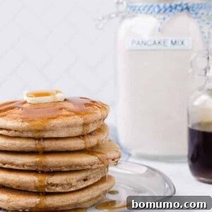 Image of a stack of pancakes with homemade pancake mix in the background.