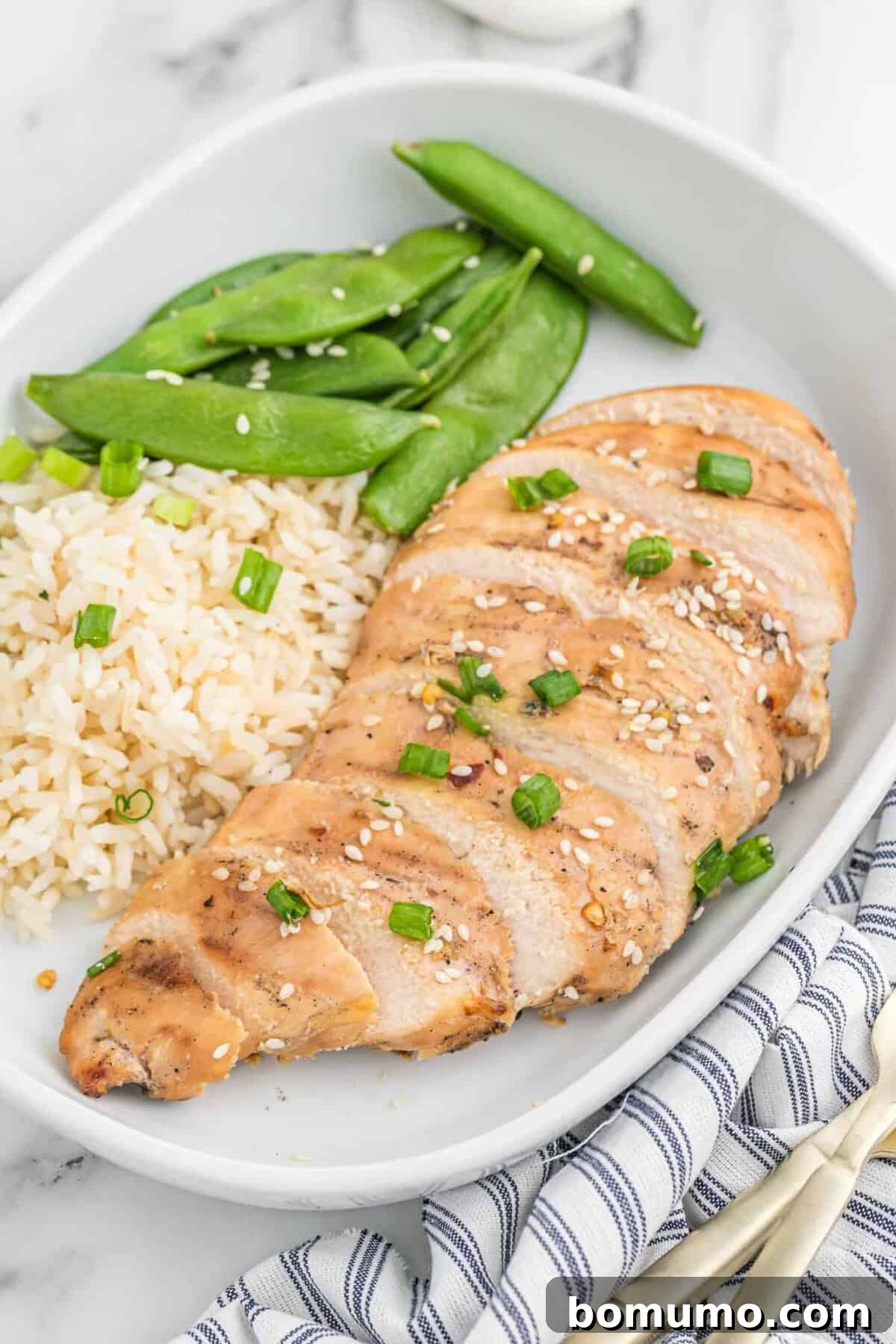 Tender, flavorful chicken, seasoned with Asian marinade, served on a plate.