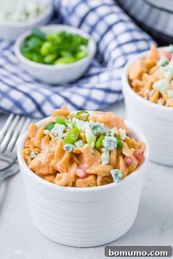 Buffalo Chicken Pasta 2 Image of a bowl of instant pot buffalo chicken pasta garnished with green onions and blue cheese.