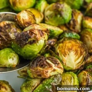 Close up of perfectly done air fryer brussels sprouts cut in half, showcasing their crispy edges.