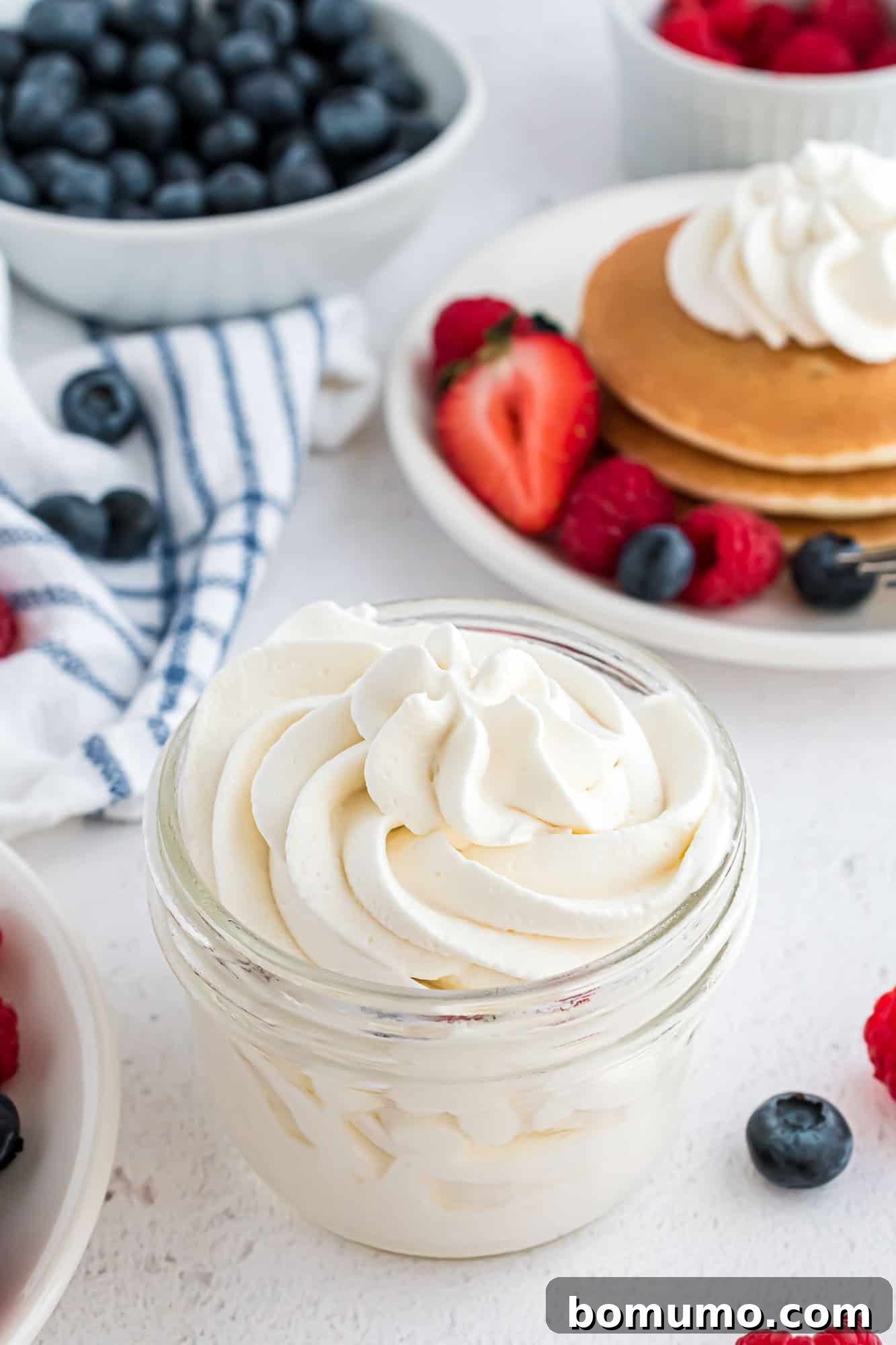 Homemade whipped cream in a small glass jar, ready to serve.