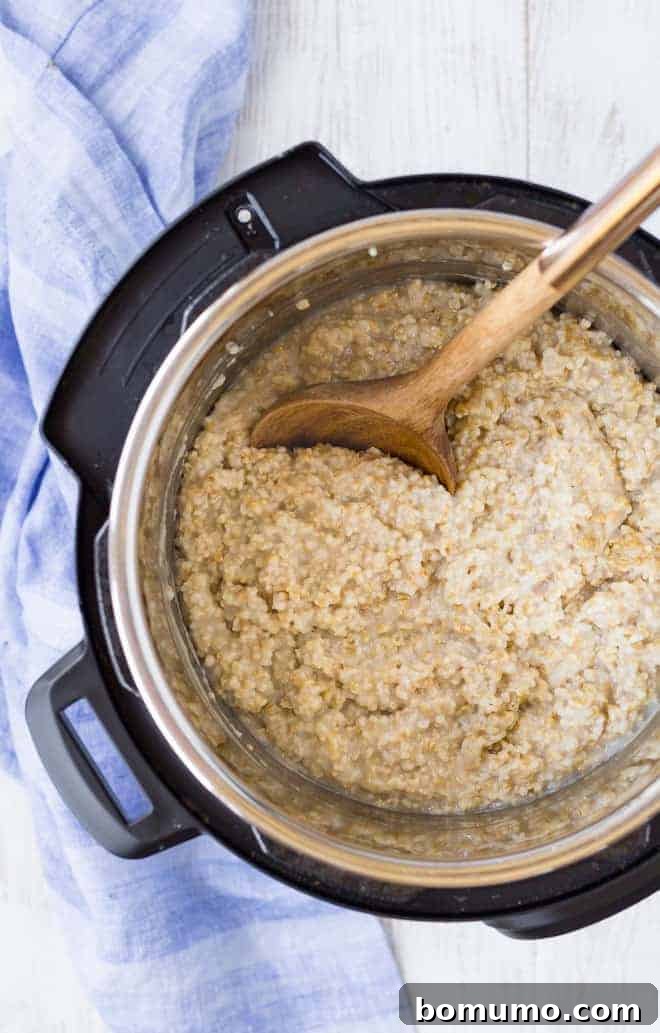 Image of steel cut oatmeal in an instant pot with a wooden spoon.