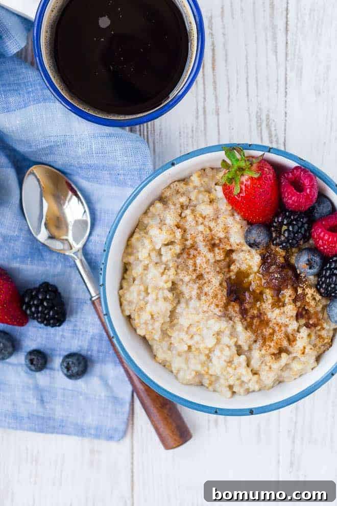 Photograph of pressure cooker steel coat oats, topped with berries. A spoon and a cup of coffee are also pictured.