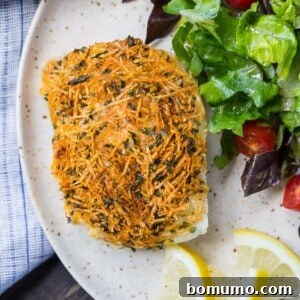 Close-up of a crispy Parmesan baked cod fillet, golden brown and perfectly cooked.