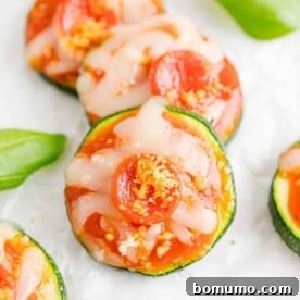 Zucchini pizza bites garnished with fresh basil, offering a low-carb appetizer option.