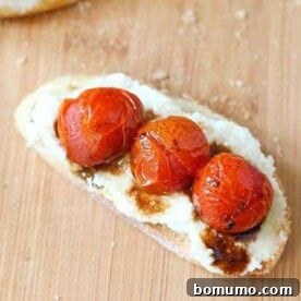 Overhead close-up of a single crostini topped with roasted tomatoes, ricotta, and balsamic glaze.