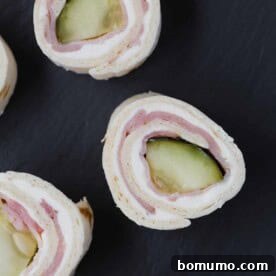 Neatly arranged pickle roll-ups with ham, cut into festive pinwheels.