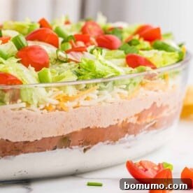 Straight-on view of a seven-layer dip in a glass dish, showcasing its vibrant layers.