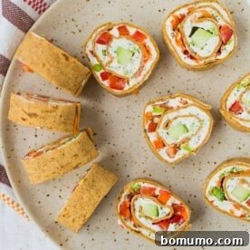 Colorful vegetable cream cheese roll-ups filled with crisp veggies and flavorful herbs.
