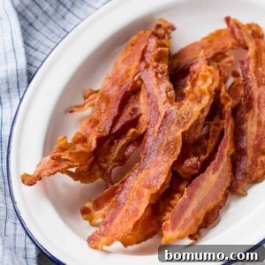 Crispy baked bacon on a white platter.