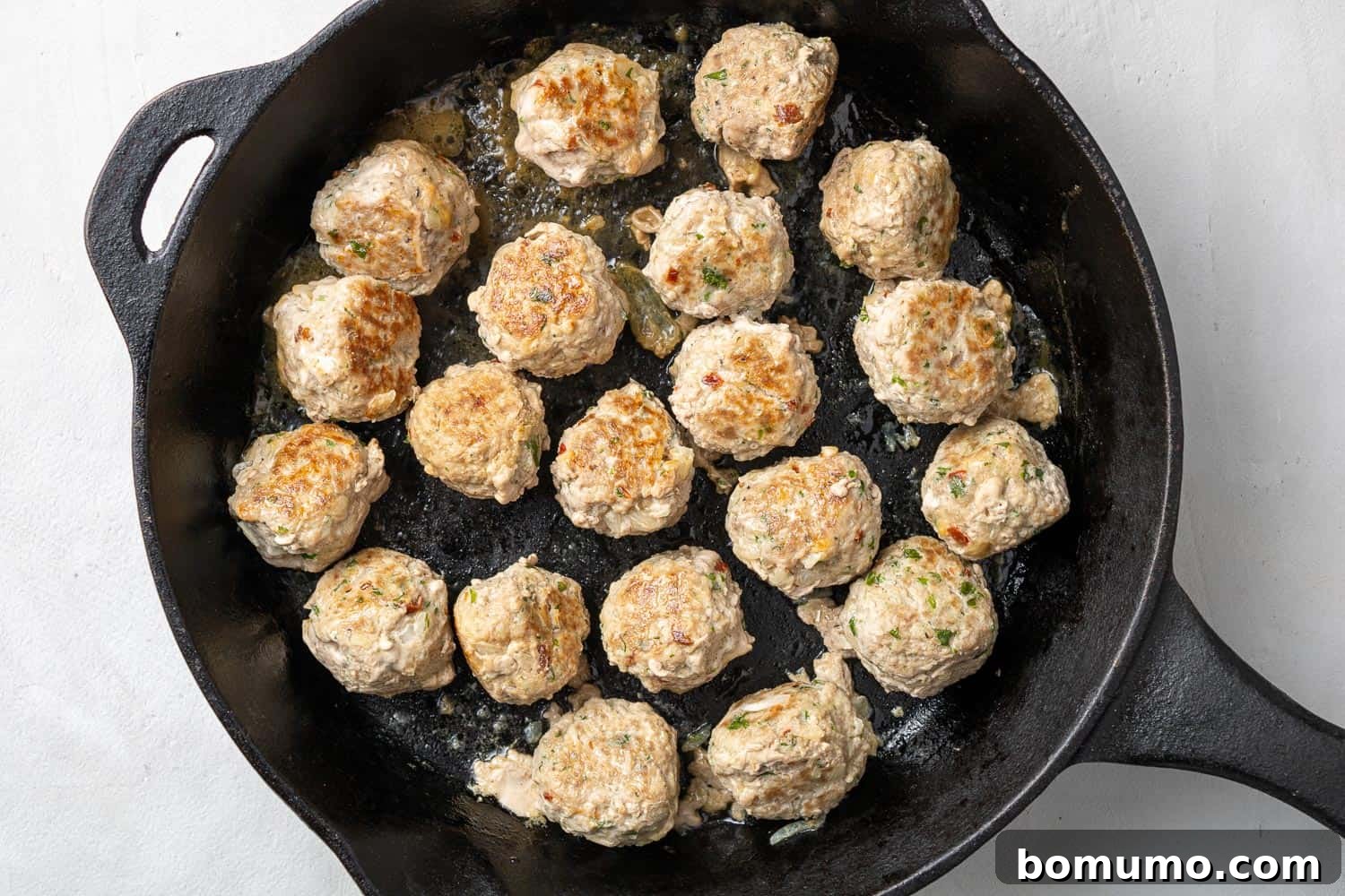 Meatballs in a black cast iron skillet.