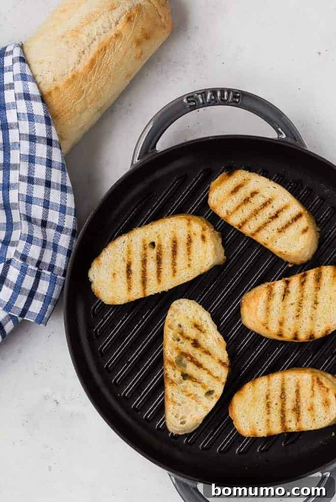 Crafting Perfect Crostini 4 Sliced bread being toasted in a grill pan, showing distinctive grill marks, for a flavorful crostini base.